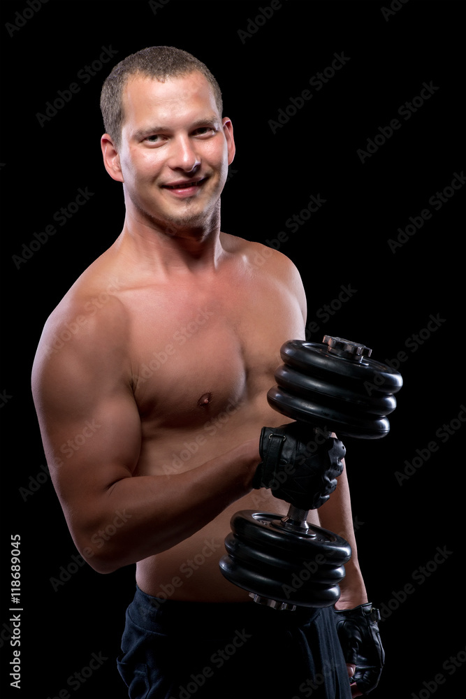 Happy bodybuilder with dumbbell with a naked torso