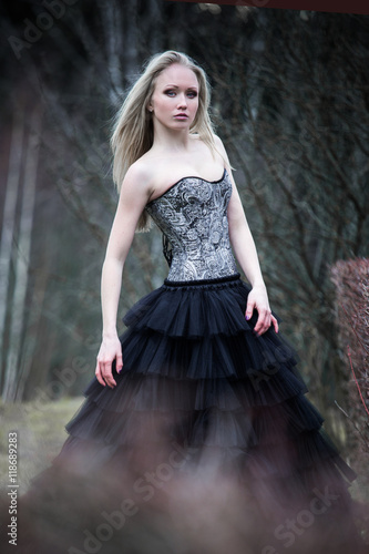 Portrait of beautiful girl in black dress in nature