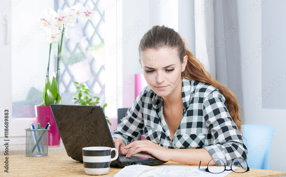 Young woman working in home office using laptop Young woman working in home office using laptop