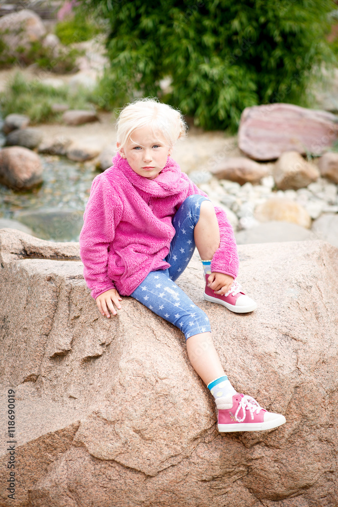 Portrait of a little beautiful girl blonde near the fountain, Park, Russia Portrait of a little beautiful girl blonde near the fountain, Park, Russia