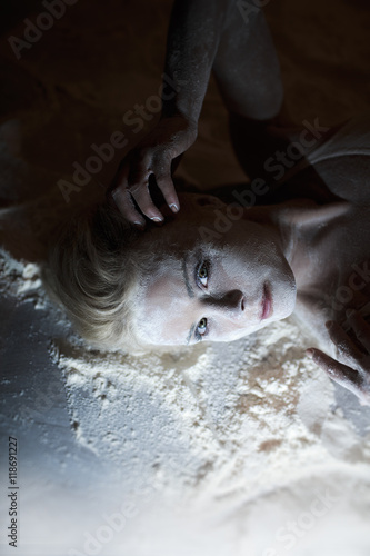 Portrait of beautiful woman lying on the floor with flour