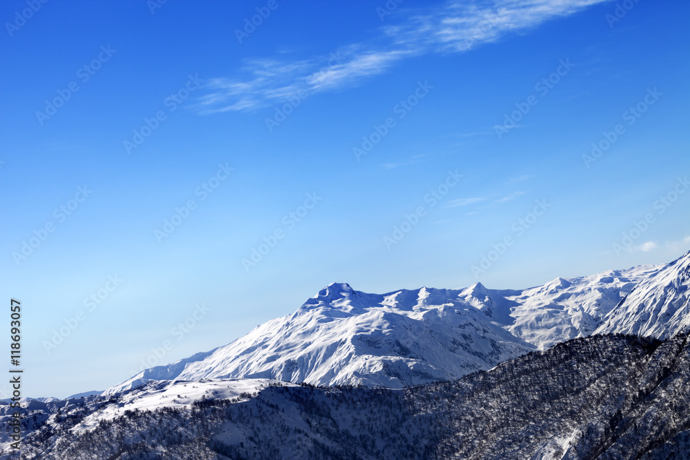 Snowy mountains and blue sky in early sunny morning