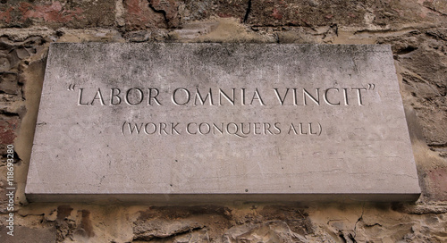 Labor omnia vincit. A Latin phrase meaning Work conquers all. Engraved text. photo