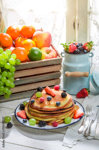 Tasty pancakes with fruits and maple syrup