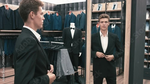 The man in the fitting room, looking in the mirror in shop