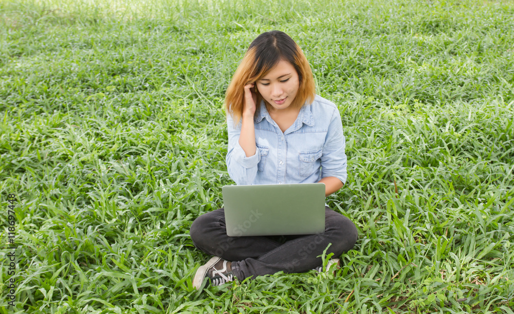 Young student relax in the park. work with laptop in green grass Young student relax in the park. work with laptop in green grass