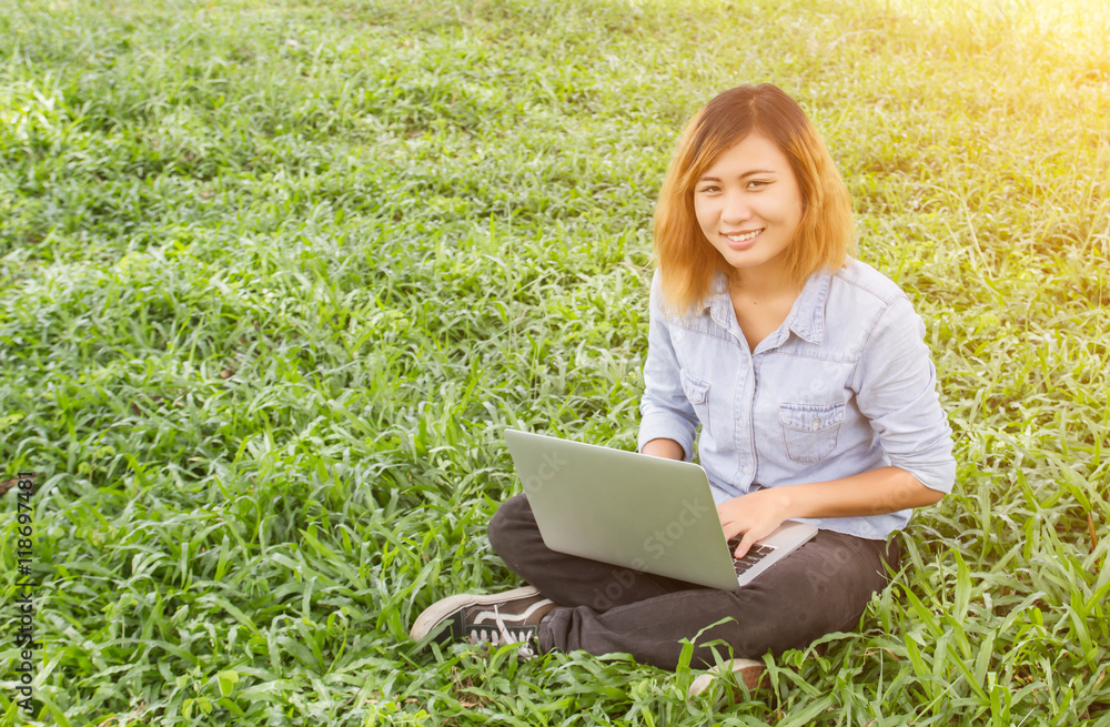 Young student relax in the park. work with laptop in green grass Young student relax in the park. work with laptop in green grass
