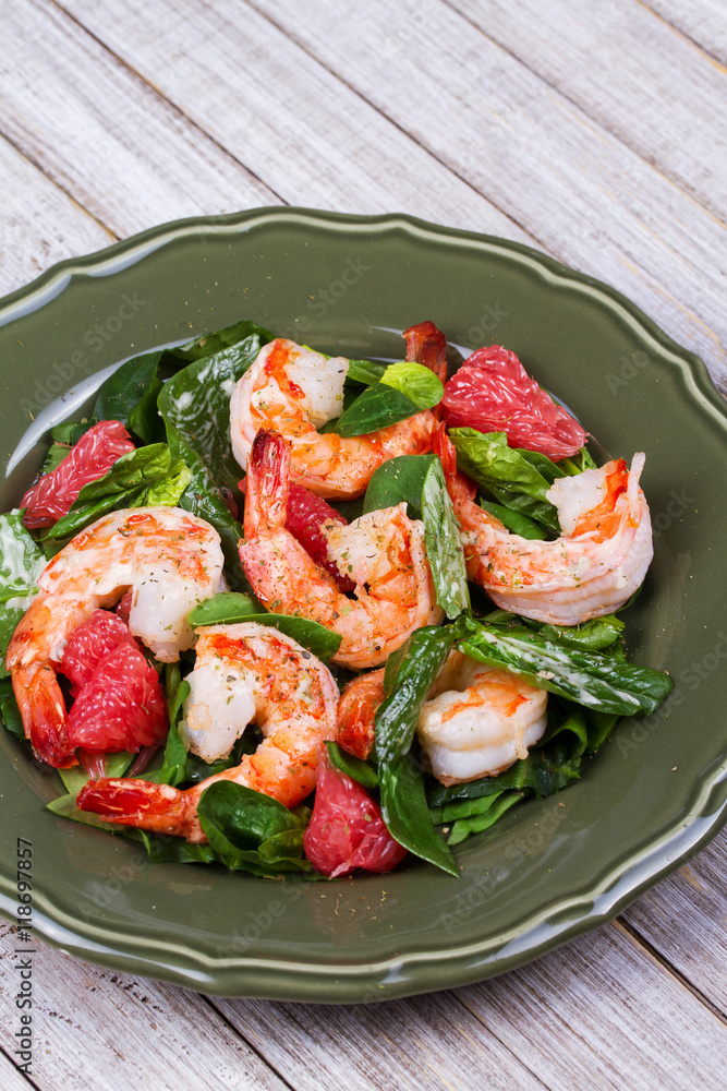 Shrimp, grapefruit and spinach salad in green plate Shrimp, grapefruit and spinach salad in green plate