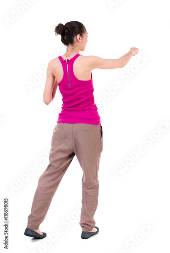 back view of woman funny fights waving his arms and legs. Rear view people collection. backside view of person. Isolated over white background. dark-skinned girl in a red t-shirt boxing.