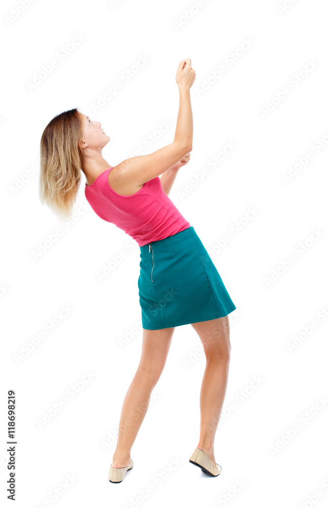 back view of standing girl pulling a rope from the top or cling to something. girl watching. Rear view people collection. backside view of person. Isolated over white background. Blonde in a red back view of standing girl pulling a rope from the top or cling to something. girl watching. Rear view people collection. backside view of person. Isolated over white background. Blonde in a red