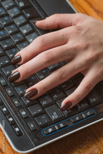 Female hands against the keyboard