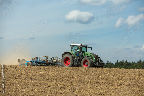 Tractor with cultivator handles field before planting