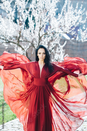 Woman in red dress near blossom