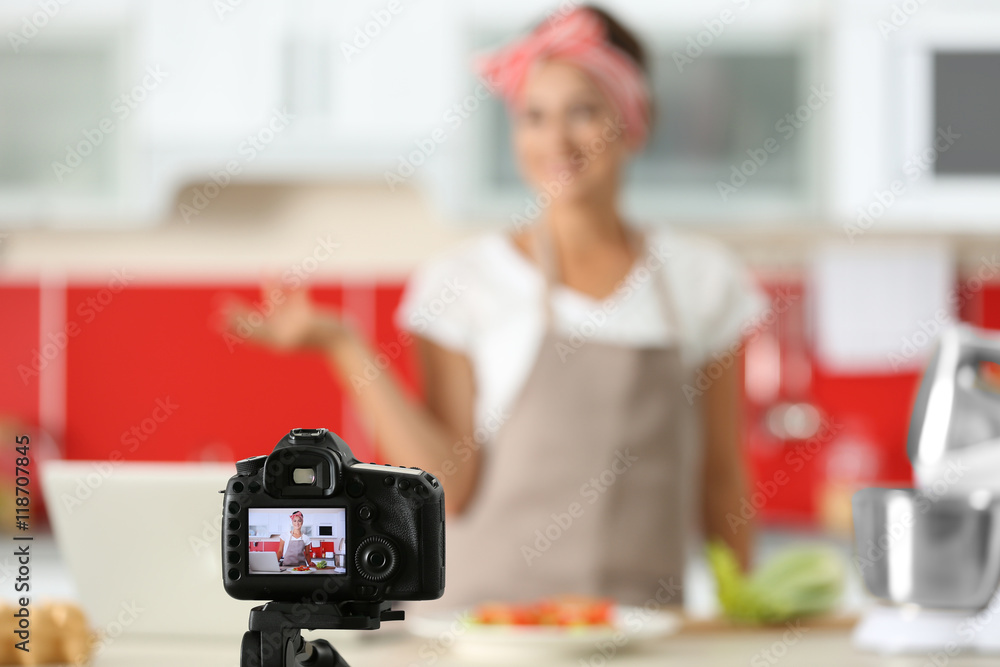 Beautiful girl recording video on camera at kitchen. Food blogger concept Beautiful girl recording video on camera at kitchen. Food blogger concept