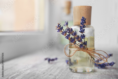 Fototapeta Naklejka Na Ścianę i Meble -  Glass bottle with spa oil and lavender flower, closeup