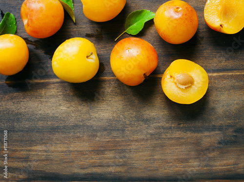 Yellow plums on wooden background with copy space. Stone fruits