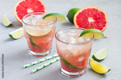 Cold pink cocktail with fresh grapefruit, lime and ice cubes