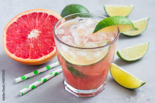 Cold pink cocktail with fresh grapefruit, lime and ice cubes