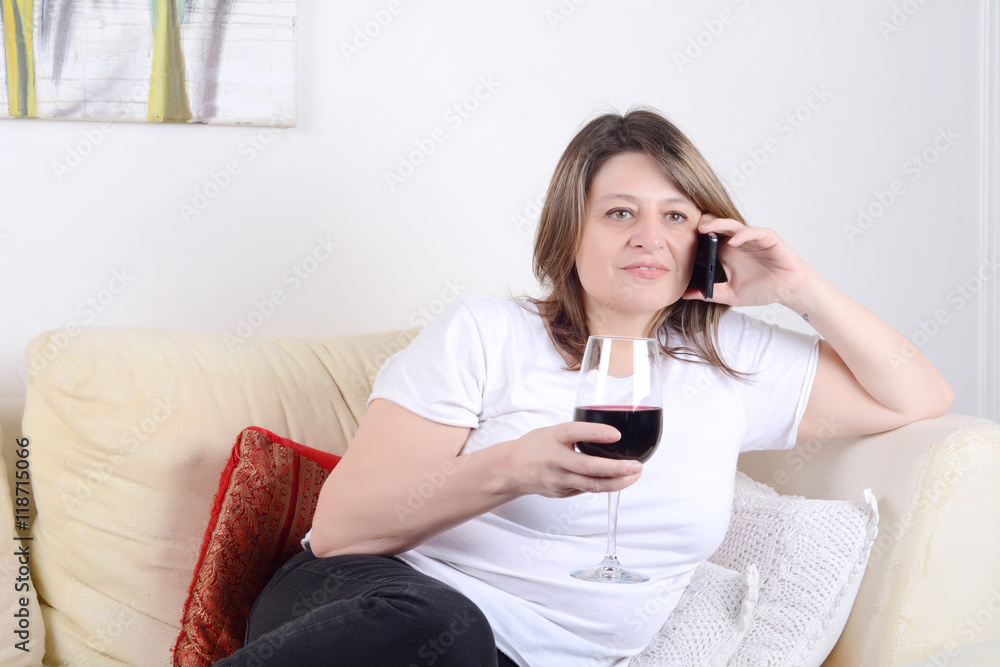 Woman with a glass of wine and talking on phone. Woman with a glass of wine and talking on phone.