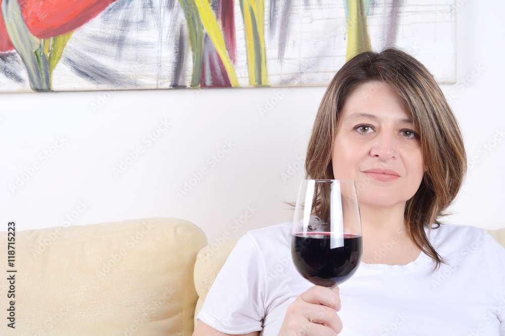 Woman relaxed on sofa with a glass of wine.
