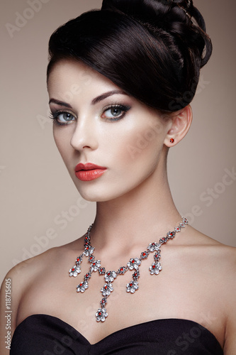 Fashion portrait of young beautiful woman with jewelry. Brunette girl. Perfect make-up. Beauty style woman with diamond accessories