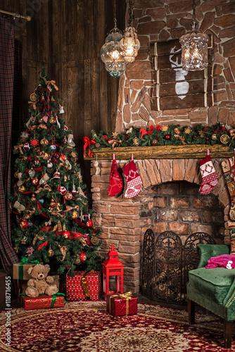 Christmas decorations: a green chair by the fireplace, a tree with toys and gifts