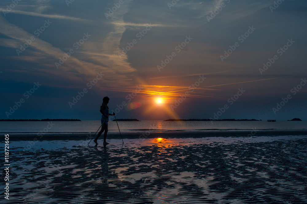 Nordic walking on the beach at sunrise