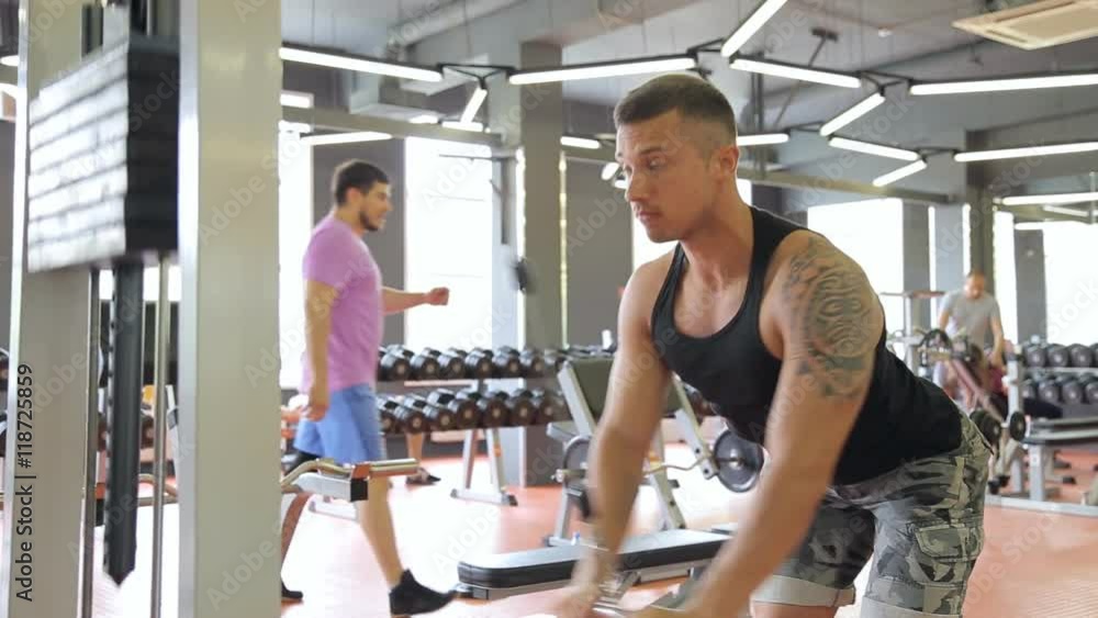 Young man doing exercises in a gym, workout Young man doing exercises in a gym, workout