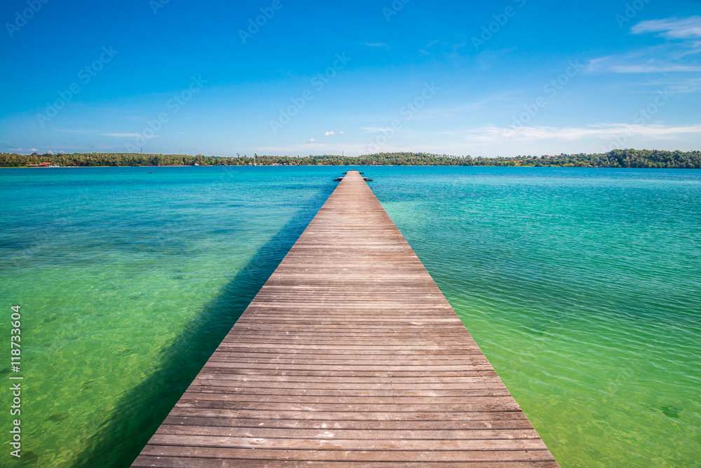 Long wooden bridge on beautiful tropical island beach - Travel summer vacation concept.