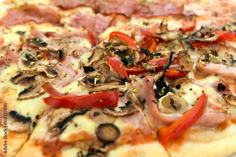 Pizza with mushrooms, ham, red pepper and herbs. Close-up. Pizza with mushrooms, ham, red pepper and herbs. Close-up.