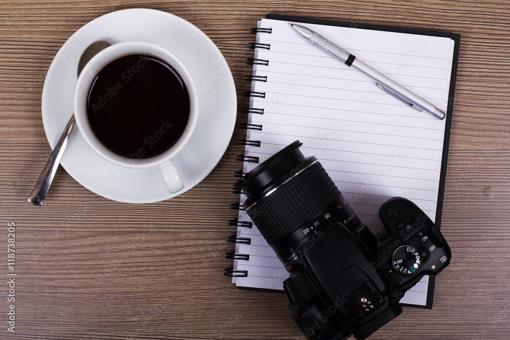 Coffee cup and camera on a wooden surface