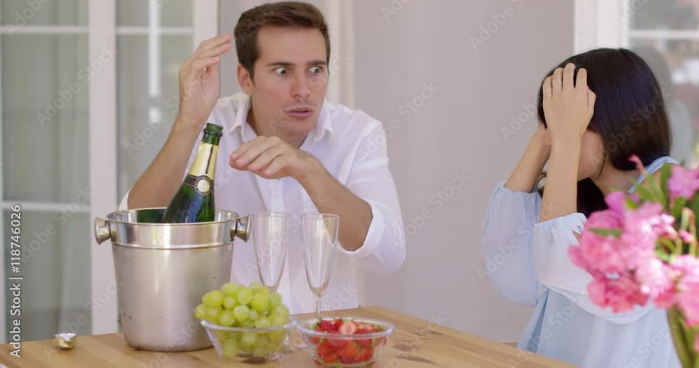 Shocked and thrilled young mixed race couple after champagne cork pooped out. They sitting at terrace of their house and celebrate. Shocked and thrilled young mixed race couple after champagne cork pooped out. They sitting at terrace of their house and celebrate.