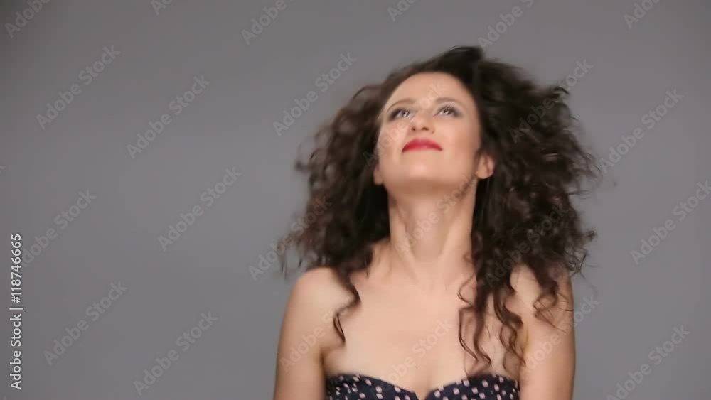 Young brunette with long brown curly hair dancing Young brunette with long brown curly hair dancing