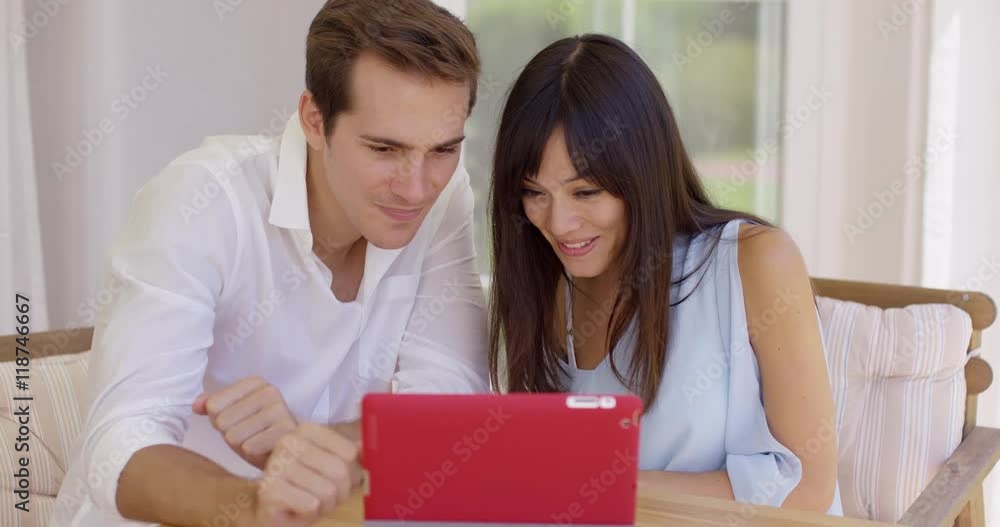 Blushing couple showing off ultrasound pictures to someone through a video chat on their tablet computer Blushing couple showing off ultrasound pictures to someone through a video chat on their tablet computer