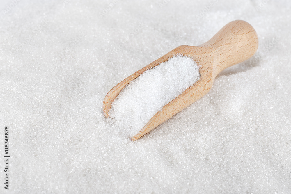 Wooden scoop on white sugar Wooden scoop on white sugar