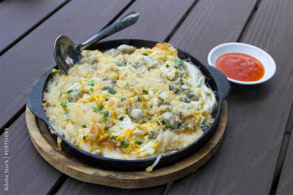 Oysters omelet on the hot pan with chili source Oysters omelet on the hot pan with chili source