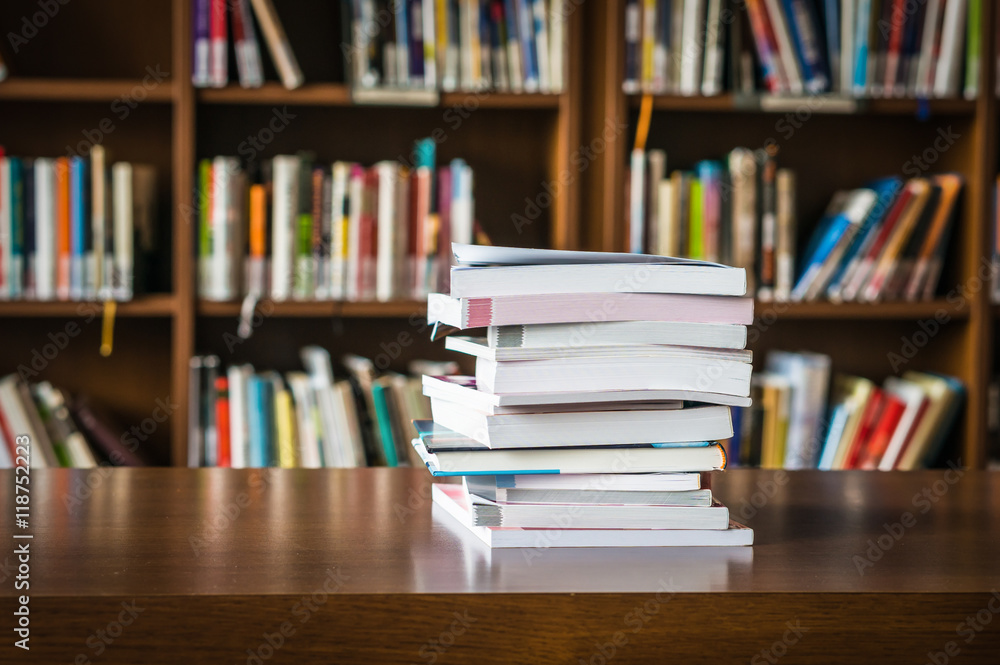 Pile of books in a library and bookshelf Pile of books in a library and bookshelf