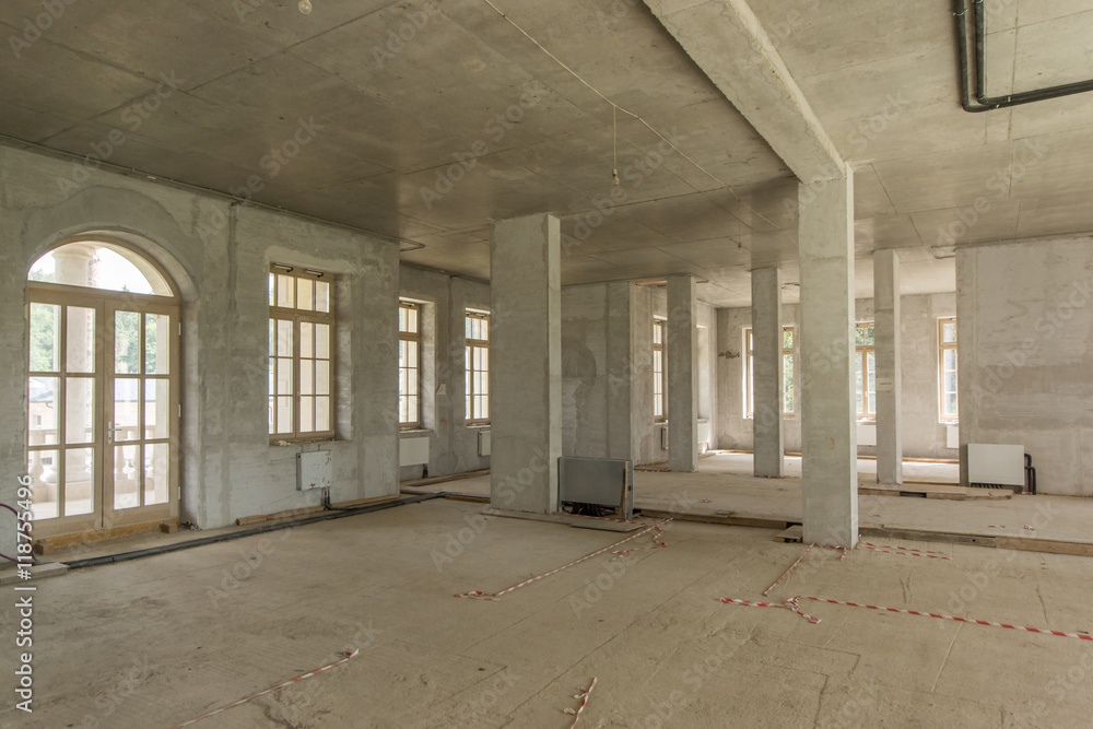 Room with concrete walls and balcony in building under construction without finishing