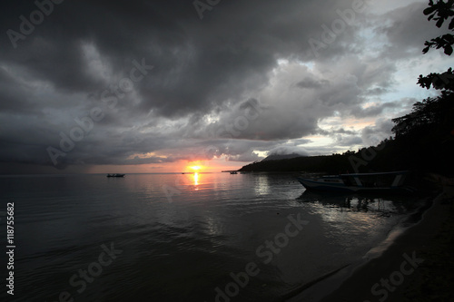 beautiful asian cloudy sunset over the ocean with shore silhouettes photo