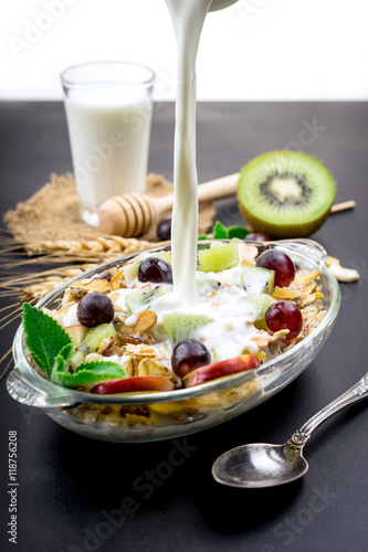 Healthy bowl of muesli, fruit, nuts and milk for a nutritious br