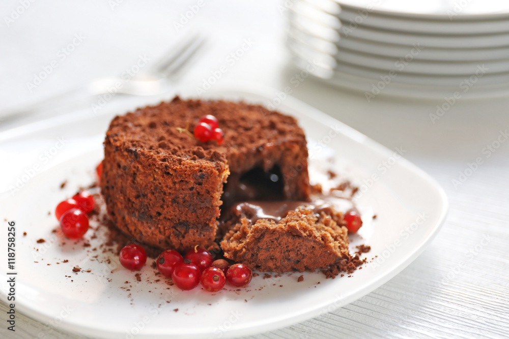 Tasty chocolate fondant with red currant on white plate, closeup Tasty chocolate fondant with red currant on white plate, closeup