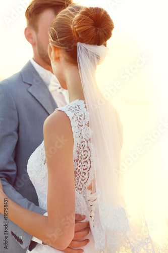 Groom and bride hugging, ou...