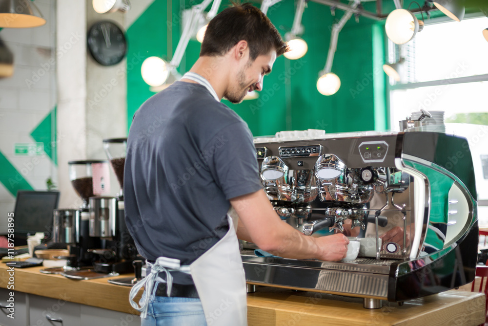 With backs male barista making coffee With backs male barista making coffee