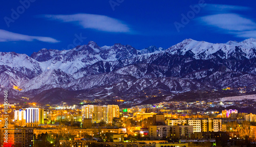 Almaty and mountains under the moonlight