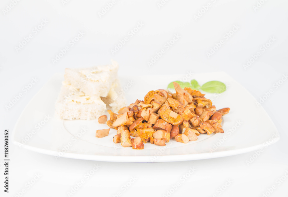 Sauteed chanterelle with garlic and some white bread on a plate decorated with basil Sauteed chanterelle with garlic and some white bread on a plate decorated with basil
