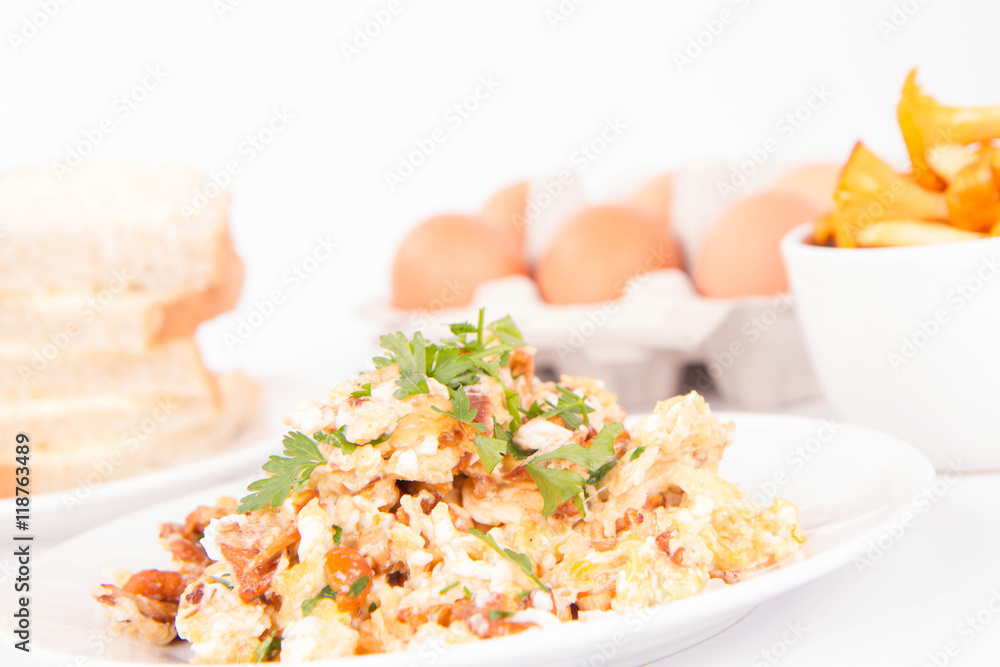 Scrambled eggs with chanterelle and parsley on a white background Scrambled eggs with chanterelle and parsley on a white background