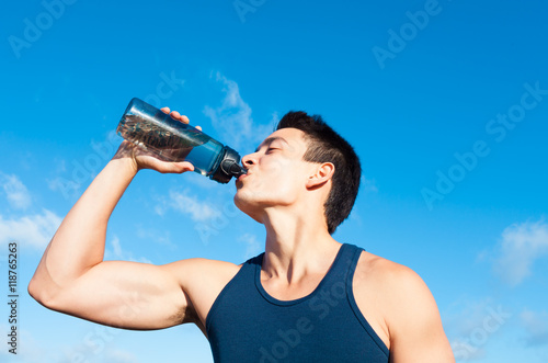 Fit man drinking bottle of water. 