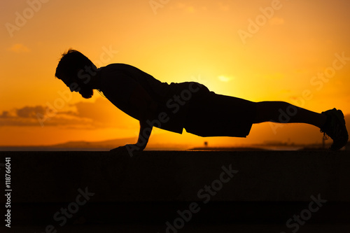 Fototapeta Naklejka Na Ścianę i Meble -  Middle ages man doing pushup exercise outdoors. 