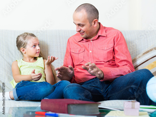 Schilderij op canvas Man and little girl with books indoors.