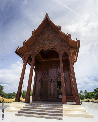 wide view of thai beautiful wooden temple,thai style carving of temple in prachuapkhirikhan province of Thailand,blue sky and cloud in background photo